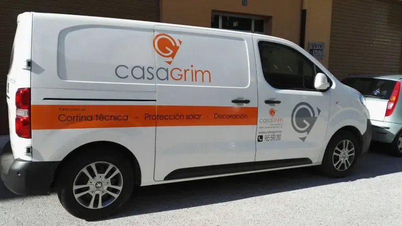 Furgoneta de CasaGrim rotulada con logotipo y franja en vinilo